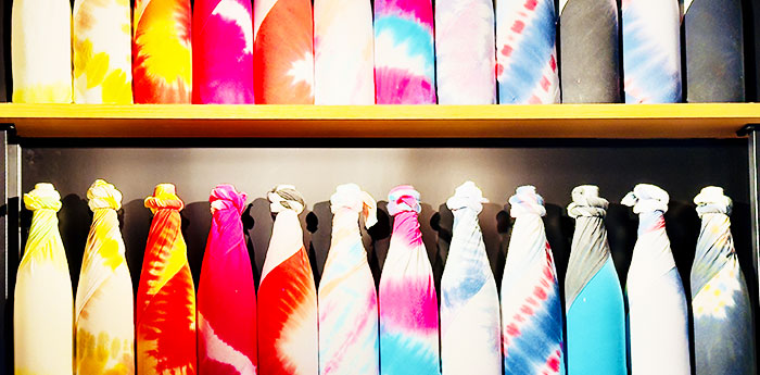 色鮮やかな模様の手ぬぐいでくるまれた酒瓶が横一列にインテリアとして並んでいる画像