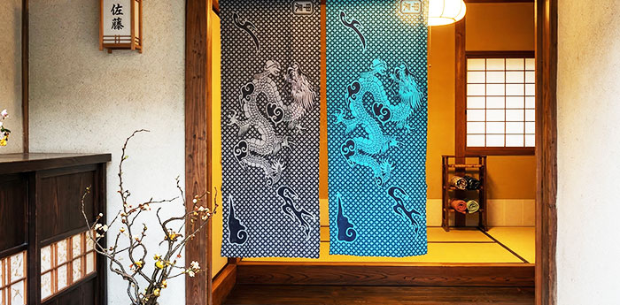 邸宅の出入口に、2枚の色が異なる手ぬぐいを縦長の長方形でのれん風に飾っている画像